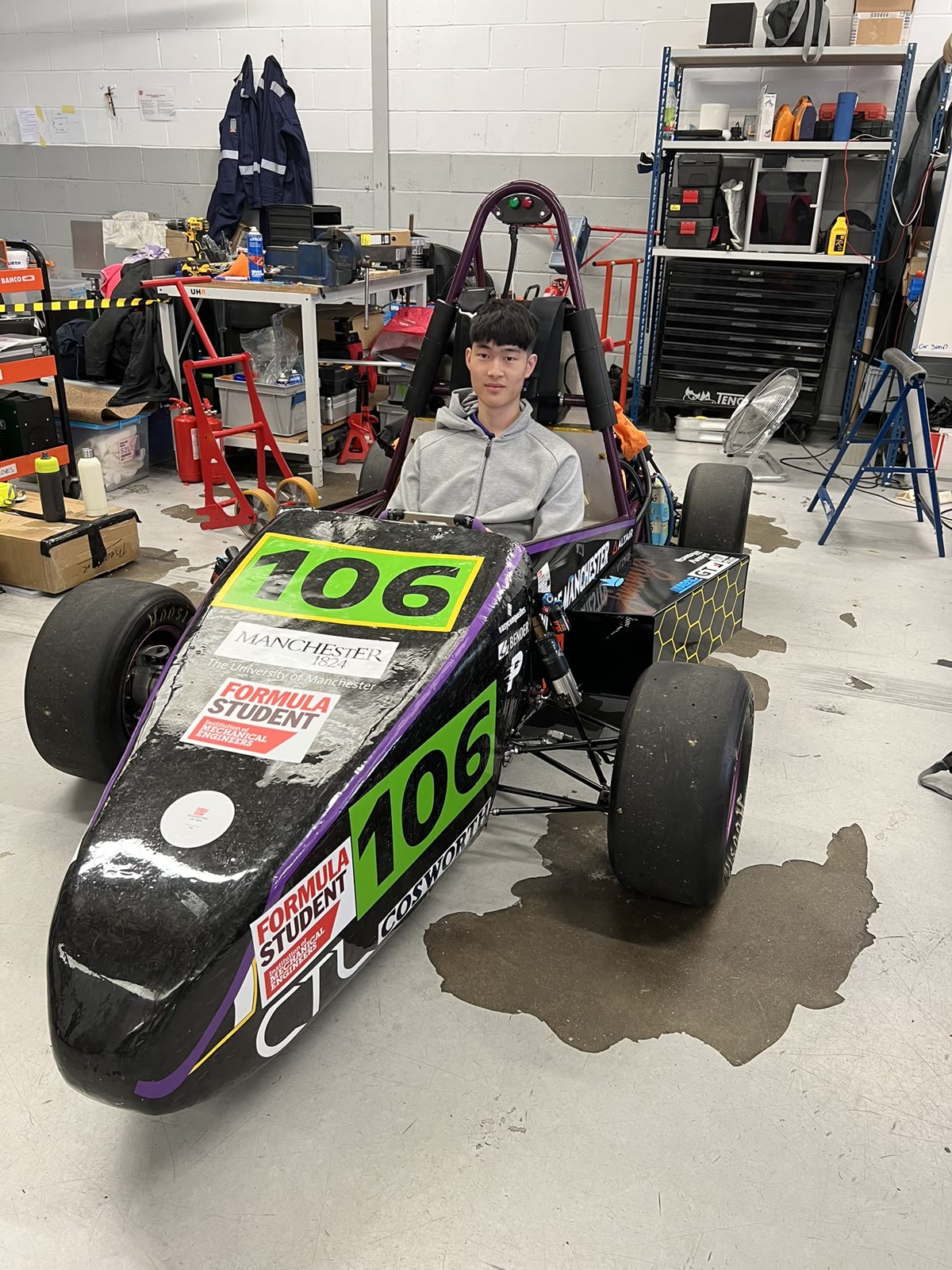 Charles seated in the University of Manchester Formula Student car in the workshop